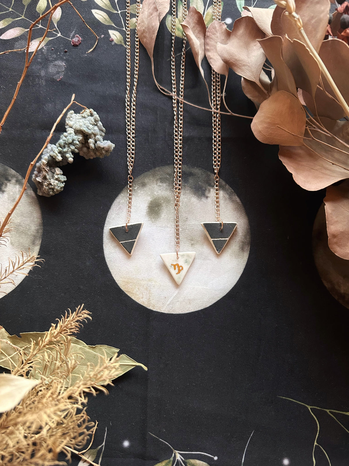 This handmade porcelain Capricorn zodiac pendant is 1” x 1”, double sided with an elemental symbol and the zodiac sign. It has a 20” chain champagne gold plated iron chain - Portland, OR by Keven Craft Rituals.